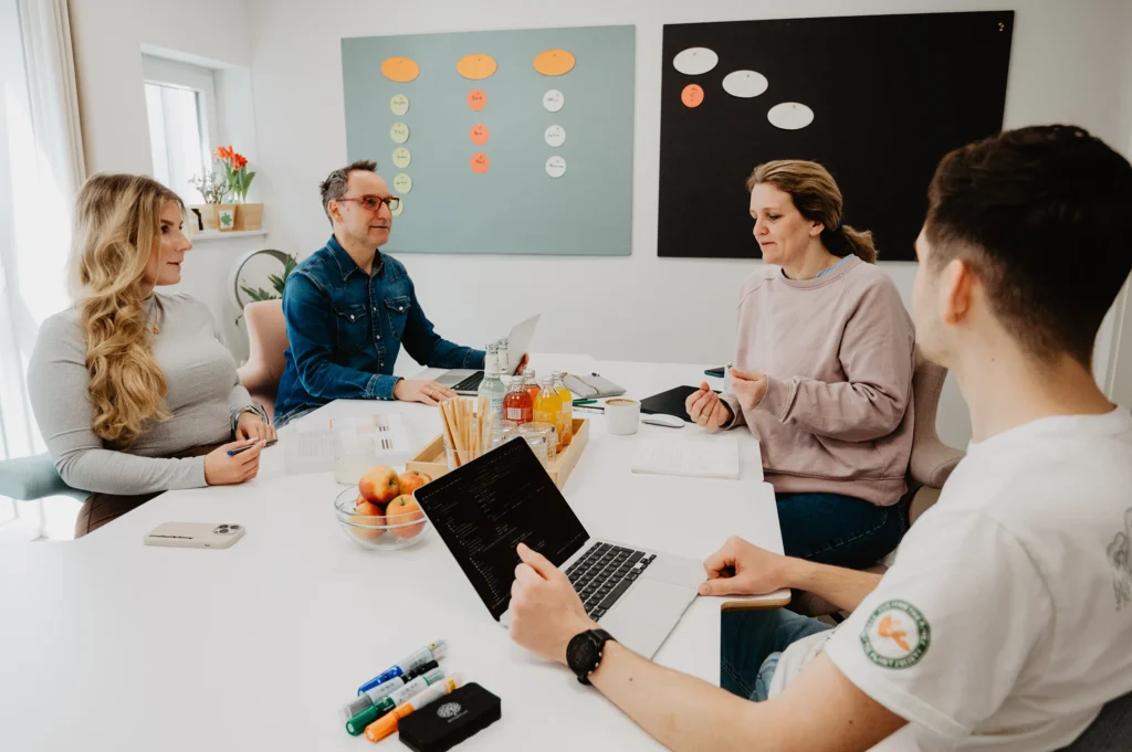 Vier Personen sitzen im Midi Meetingraum