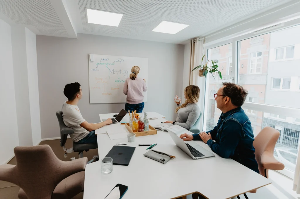 Vier Personen sitzen im Midi Meetingraum